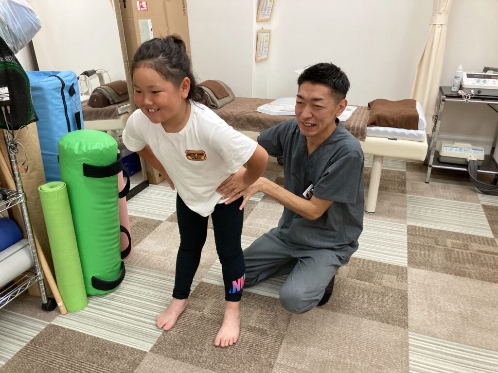 スポーツをしている女の子の患者さんと一緒にトレーニングをしている時の写真