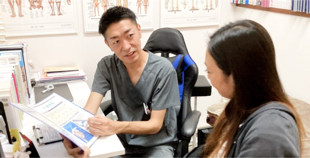 ケガや痛みの原因について先生が保護者に説明をしている時の写真。