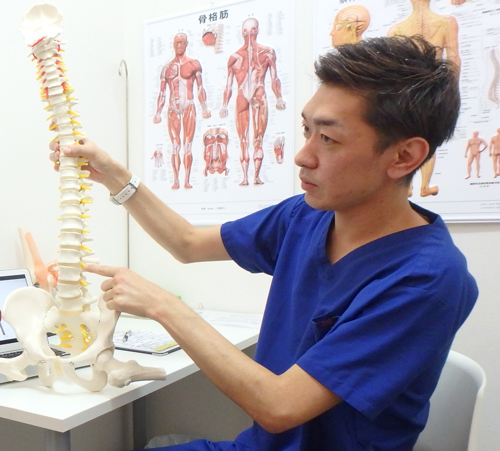 おりおスポーツ接骨院の先生が患者さんに骨模型を使って痛みの原因について説明をしているときの写真