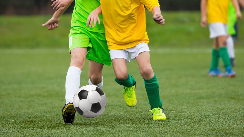 サッカーでドリブルをしている時の子どもの写真。