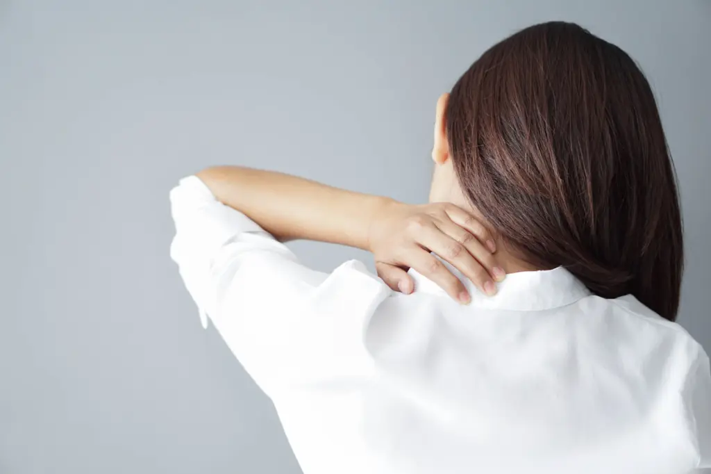 首の痛みを気にしている女性の写真。